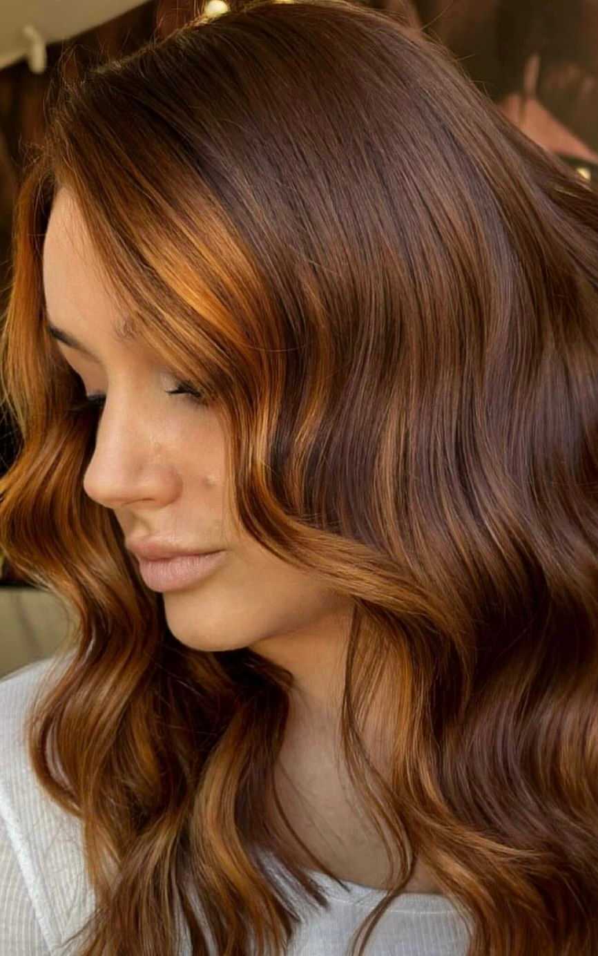 Woman with shiny chestnut brown wavy hair.