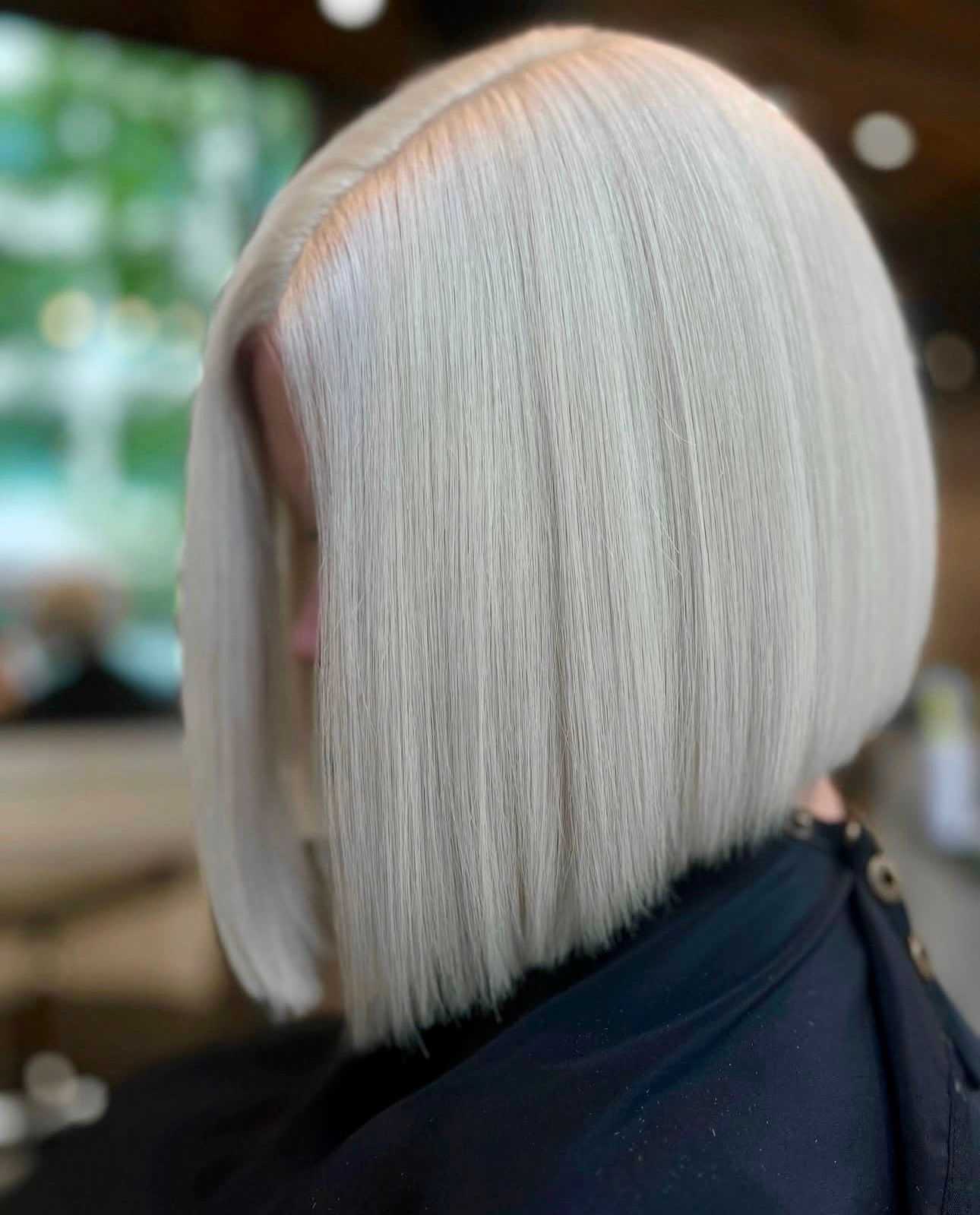Sleek platinum blonde bob hairstyle in a salon setting.